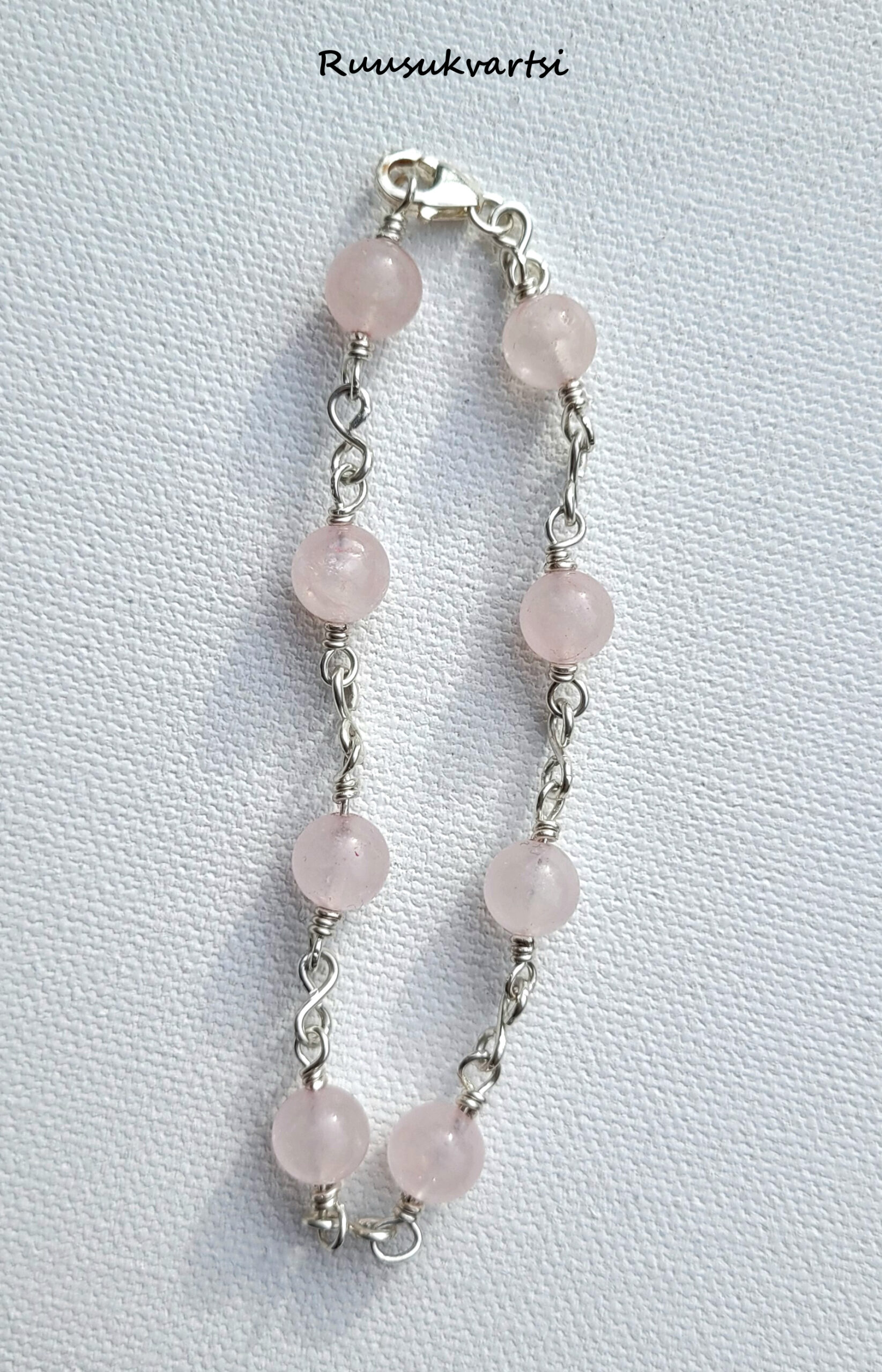 Hopeinen rannekoru, jossa ruusukvartsihelmiä